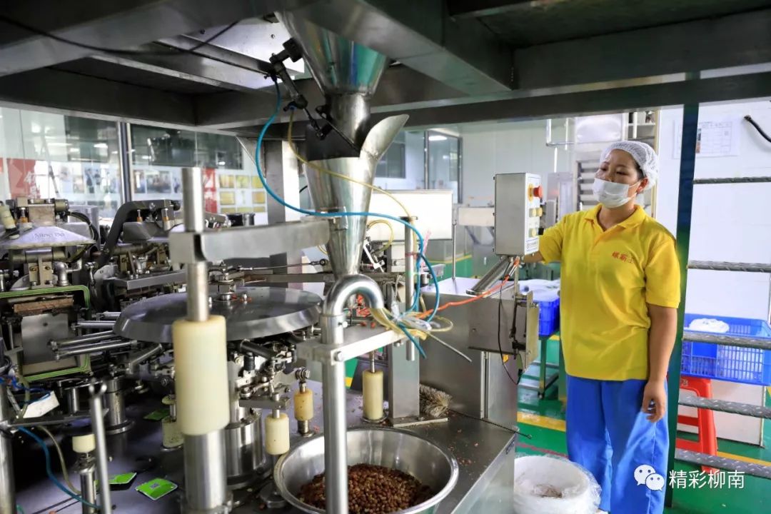 在广西柳州市柳南区某螺蛳粉生产企业生产车间,工人们在生产线上操控