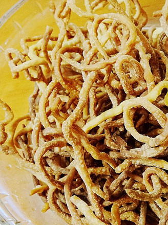 油热以后,把面条放入锅里,油炸面条~将面条放入油锅里3.