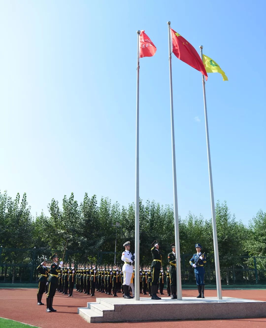 国旗护卫队队员们迈着整齐而坚定的步伐护送国旗走向旗台.