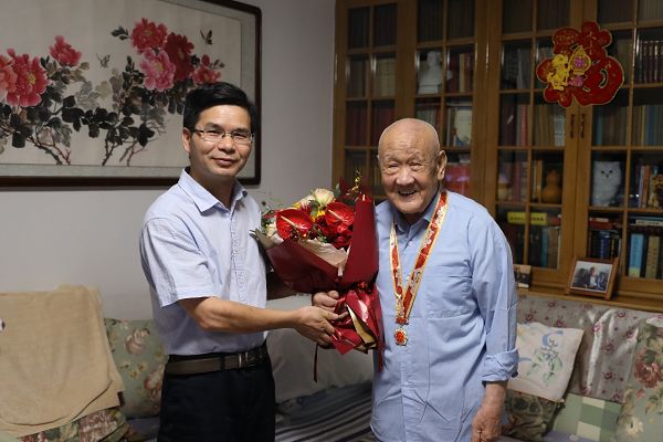 总编辑魏长宝到家中为原发行部主任王保春同志颁发纪念章.