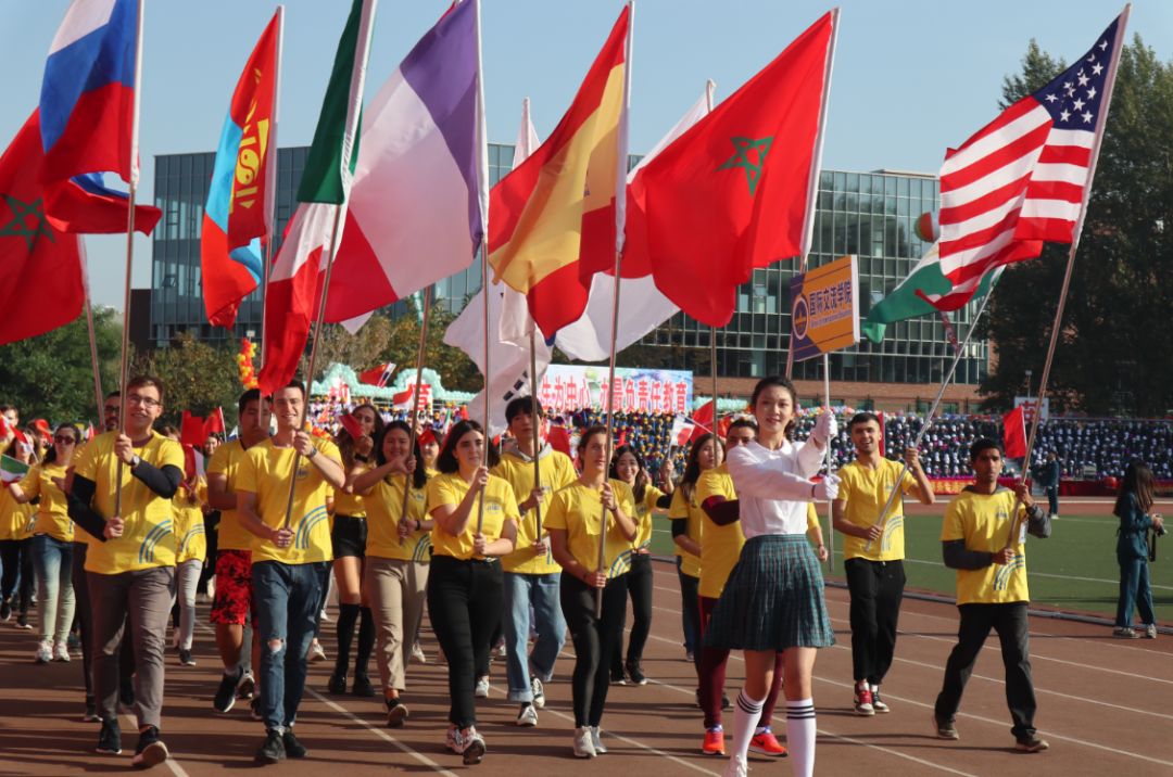 鲜花与学子的笑脸在五星红旗的映衬下,越发美丽;刀旗队,彩旗队,朝气