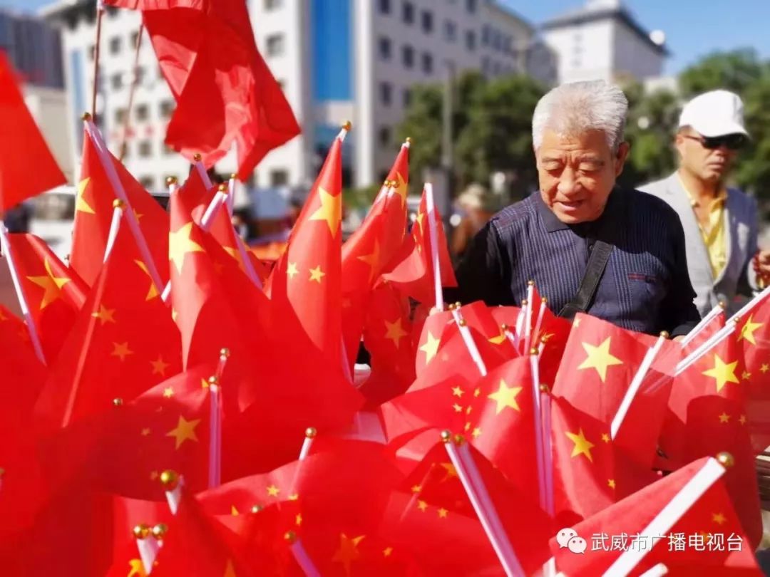 著武威人民對祖國的深情和敬意一面面鮮豔的五星紅旗迎風飄揚紅旗下