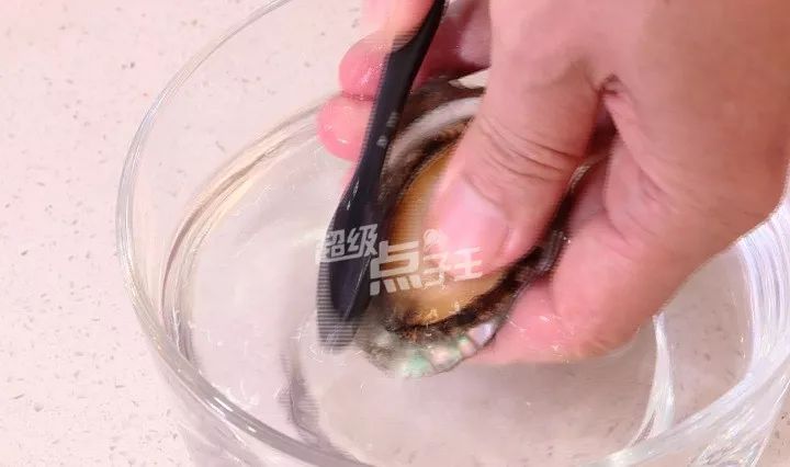 在鲍鱼上撒少许食盐,用牙刷一边刷一边冲水,把脏东西和粘液给洗掉.▽