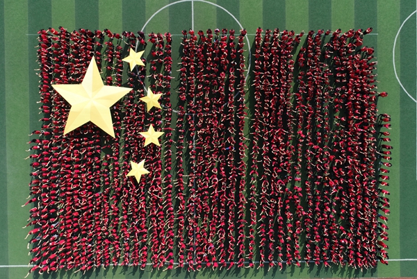 手里挥舞着国旗,拼成一副别样壮美的五星红旗,高唱《红旗飘飘》,表达