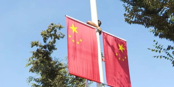 各商家门前的国旗吸引市民驻足观看,拿出手机以国旗为背景,拍下一组