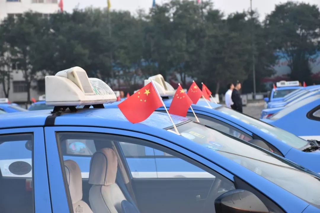 在車上插上鮮豔的五星紅旗早晨6點,我市的70多位出租車司機駕駛著自己