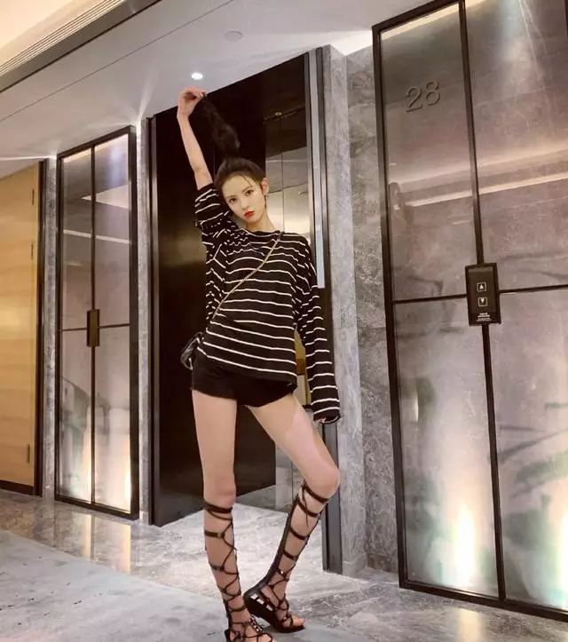 张予曦上身穿条纹上衣,下身搭黑色超短裤,超级时髦酷帅,脚踩一双绑带