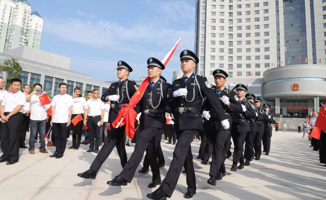迎着朝霞,由黄岩公安分局巡特警大队18名警员组成的国旗护卫队,迈着