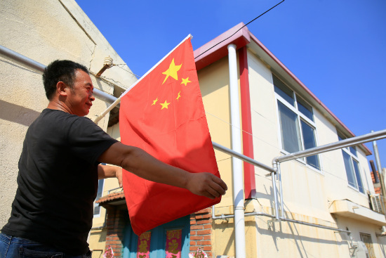 在街道,在社區,一面面鮮豔的五星紅旗隨風飄揚,平添喜慶的節日氣息