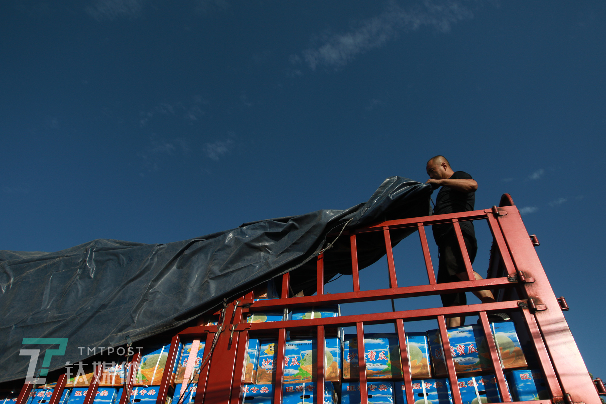 卡车车司机在给车盖油布.