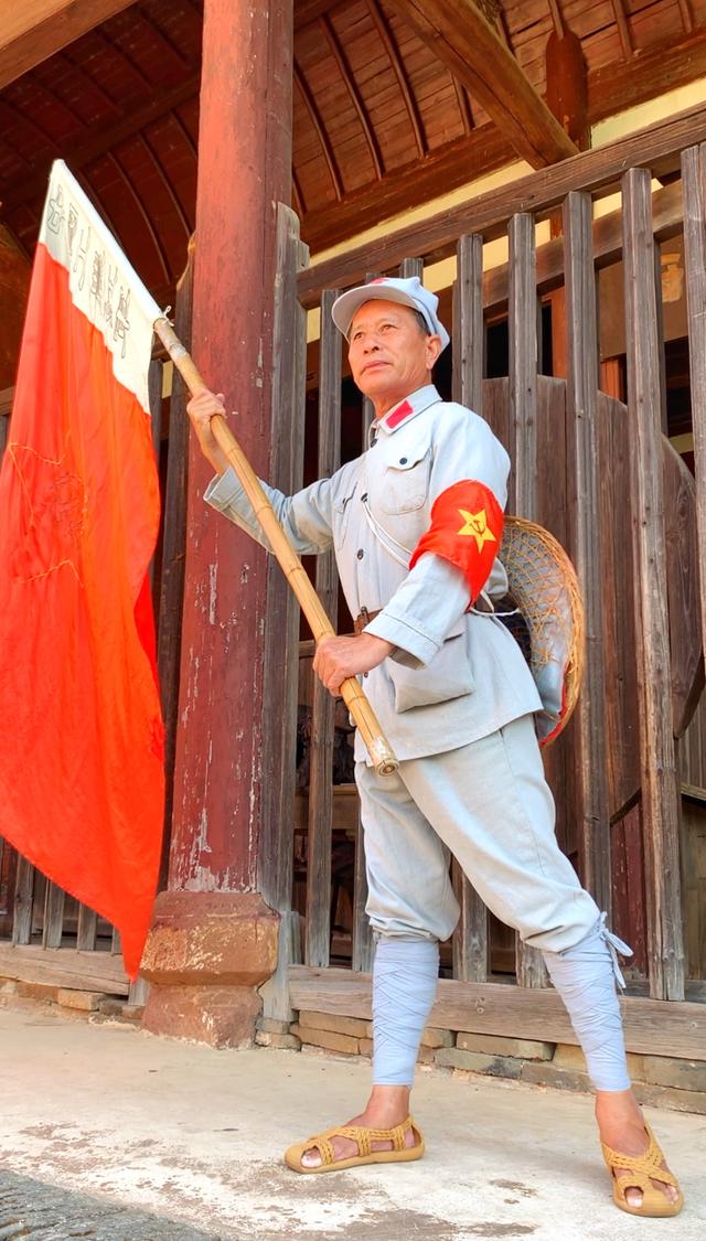 气宇轩昂,炯炯有神的眼睛,再身穿红军衣服,脚穿草鞋,手举红军旗,经常