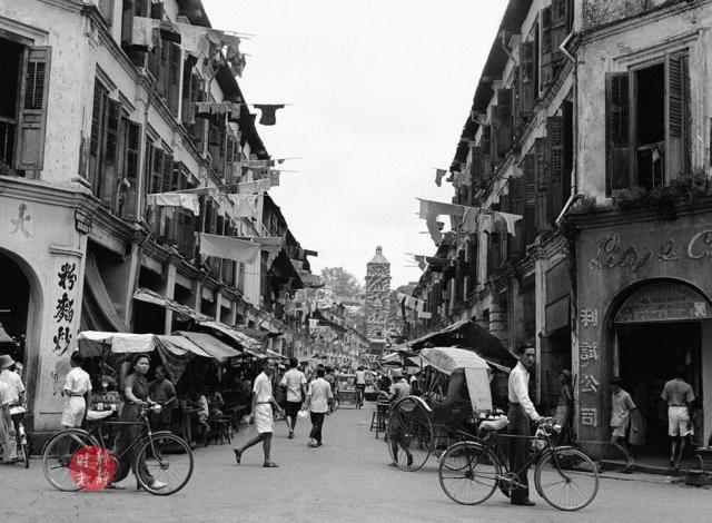 图为当时新加坡市区的一条商业街,街道两旁的建筑为店屋.