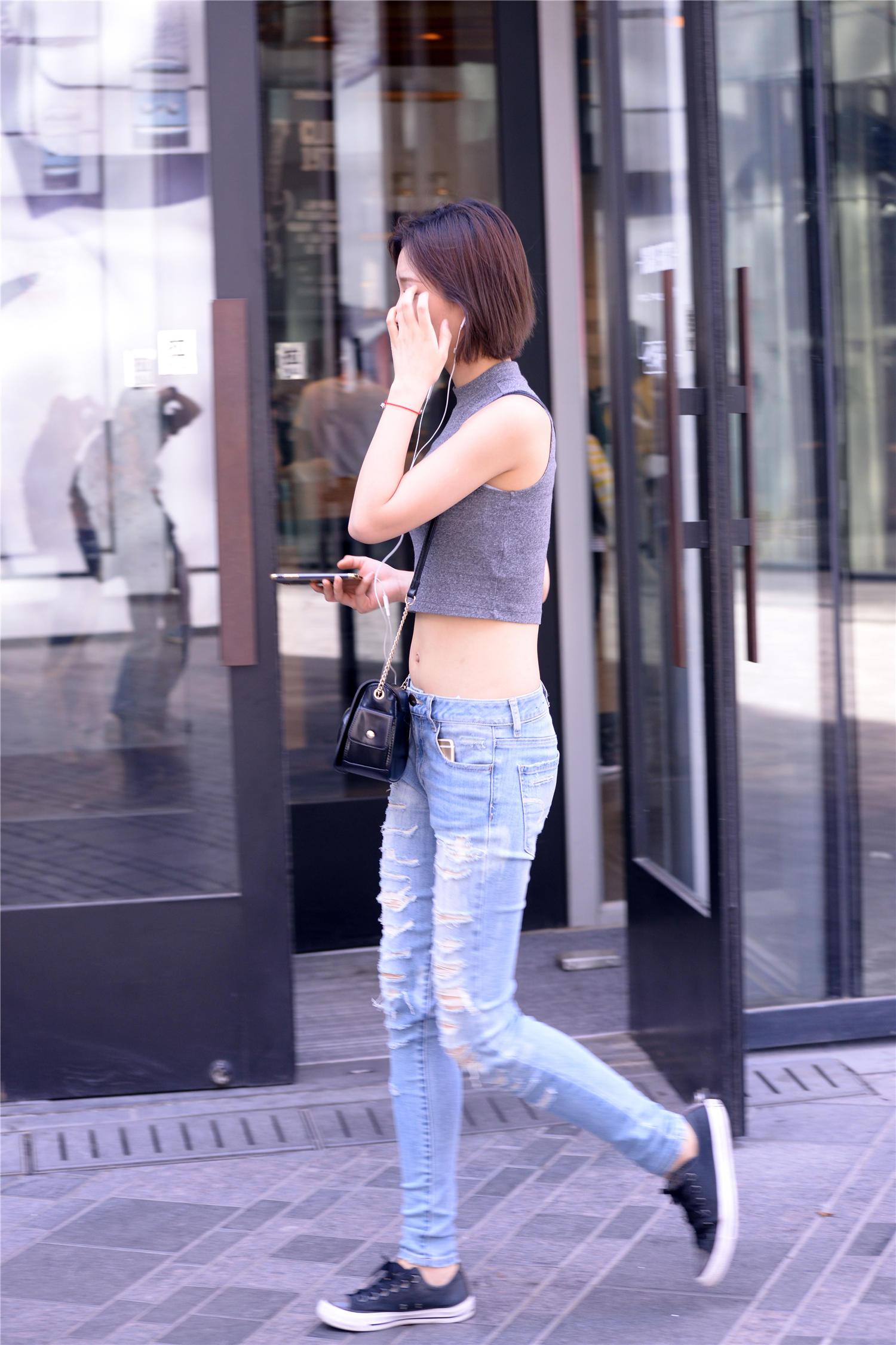 姑娘的低腰修身牛仔裤裤腿破成这样穿上要花费很多时间吧