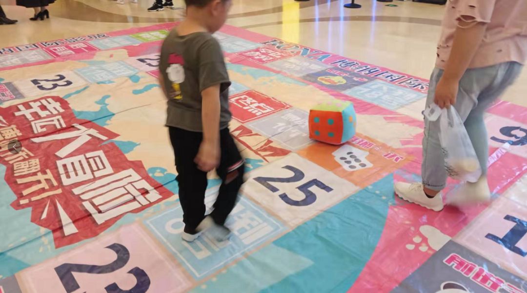 游戏规则相当简单,参与者掷骰子,按落地点数走步数,按地面图案指示