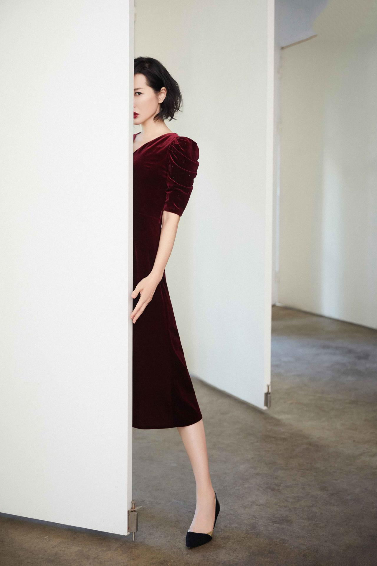 写真中她身穿红色丝绒连衣裙与黑色高跟鞋,低调优雅别具格调,另一套