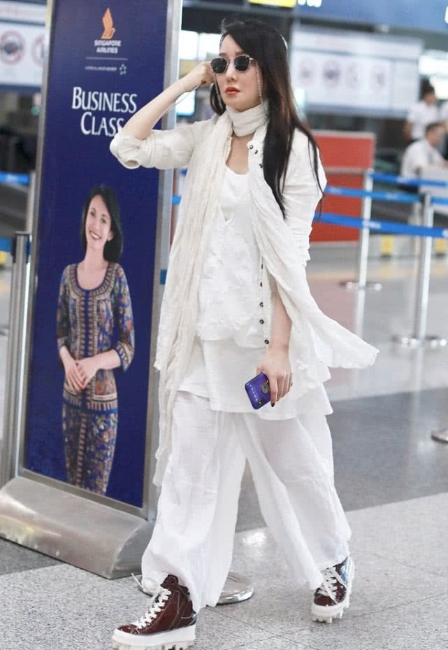 原创萨顶顶走机场,身穿一套白装还系了条丝巾,40岁了还这么仙!