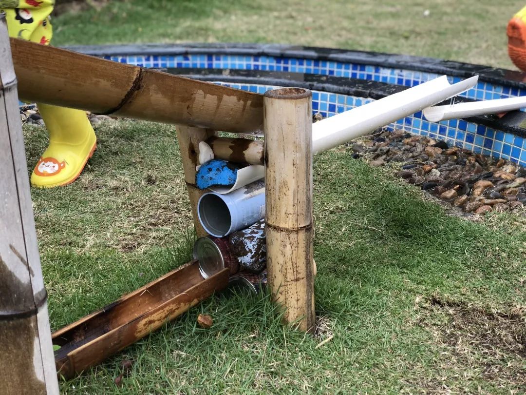 构想,竹管游戏的转折02辅助材料的投放:教师悄悄在管道边投放了小铁罐