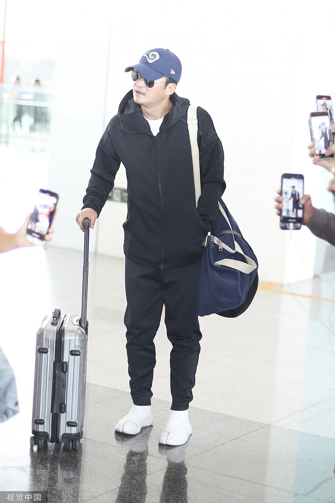 吴京身穿黑色运动装,头戴棒球帽,现身机场. 吴京上演"歪头