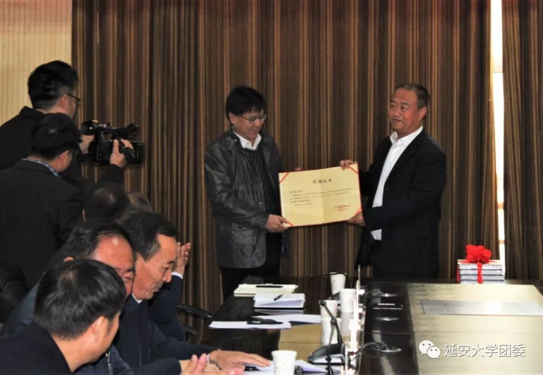 由延安大学图书馆馆长徐长玉向宜川县文旅局局长谢江龙赠送图书样品及