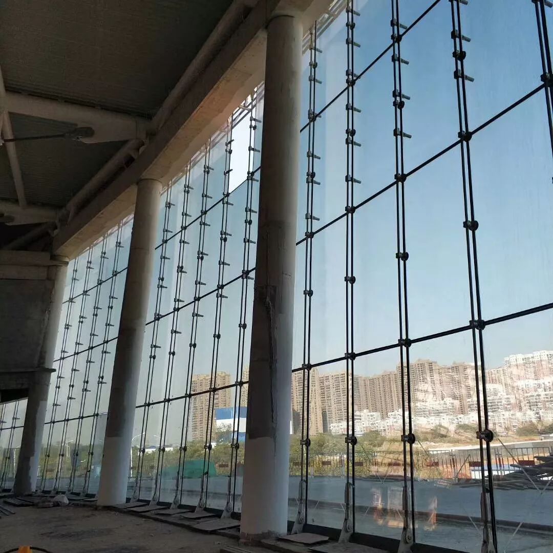 该项目体育馆,游泳馆外立面为椭圆形外倾玻璃幕墙,采用单根单向索点