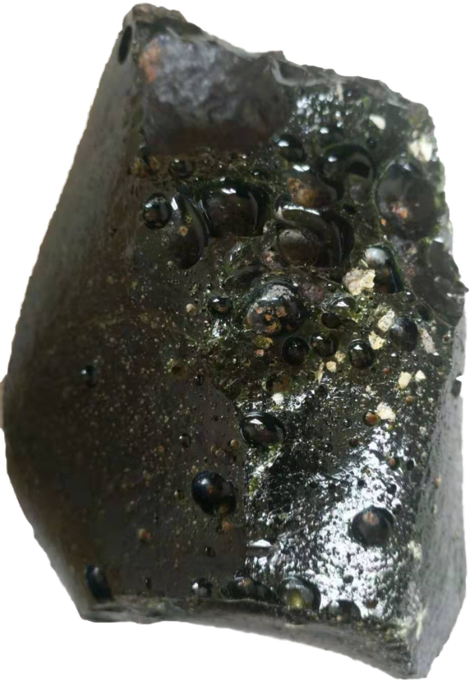 这颗玻璃陨石整体呈现墨黑色,不规则形状,表层具拉长状气泡及大小不等