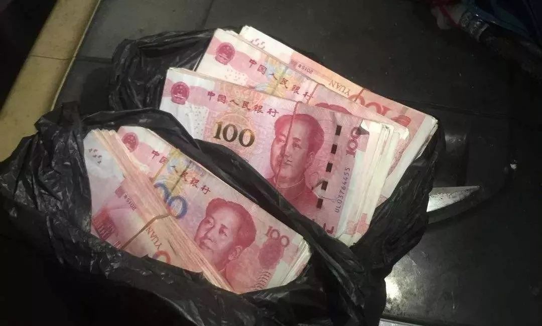面前,将装有5万元的钱袋递给了金旺,金旺从一沓钱中抽出12张百元钞票
