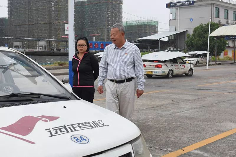 天心区远征驾校党支部书记张建明[左]和驾驶员交流.