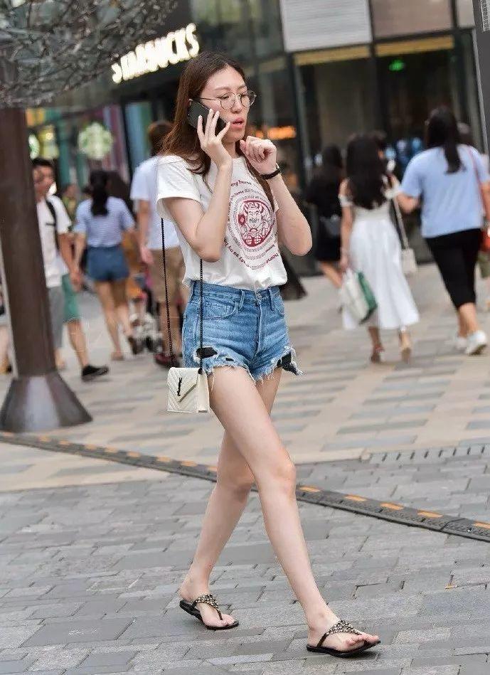 街拍美女t恤热裤的小姐姐带着一副金丝眼镜看上去很知性