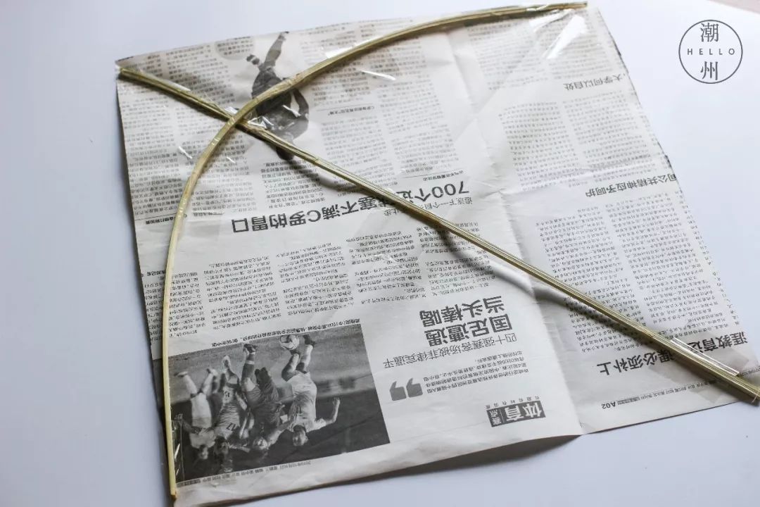将旧报纸剪出正方形的形状剩余的边角可以做尾巴两根小竹子一横一竖用