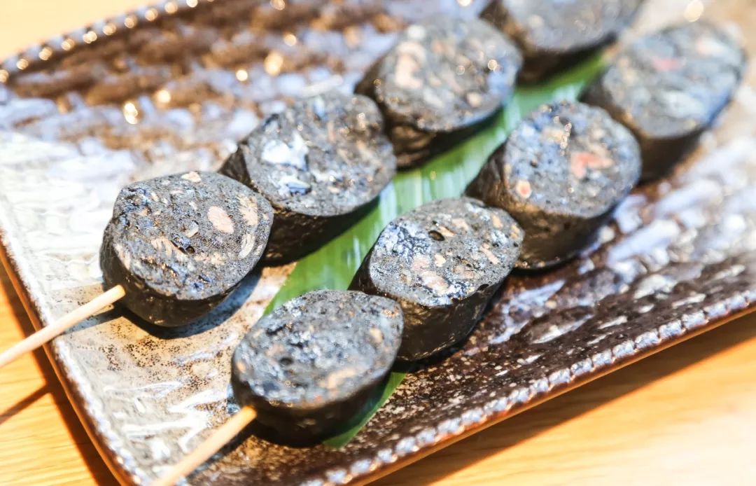 渔笙还有很多不输烧烤店的烤物烤墨鱼肠的表面黑白相间在灯光下墨鱼粒