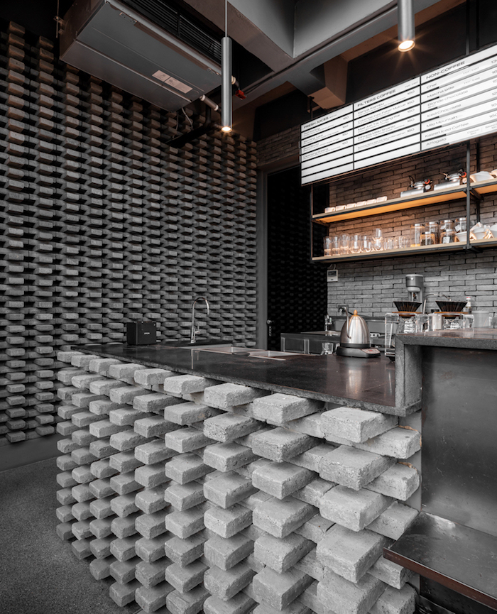 尤以一楼墙面和吧台的深灰砌砖墙,交错堆栈的造型赋予空间立体独特的