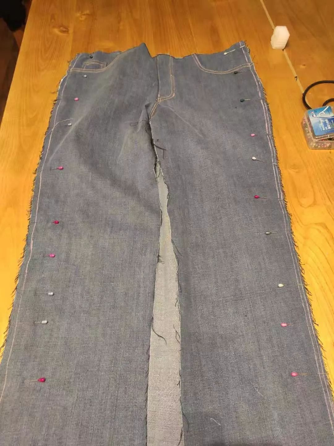 把裤子的前后片反面相对,外侧缝用珠针固定,从正面缝合.