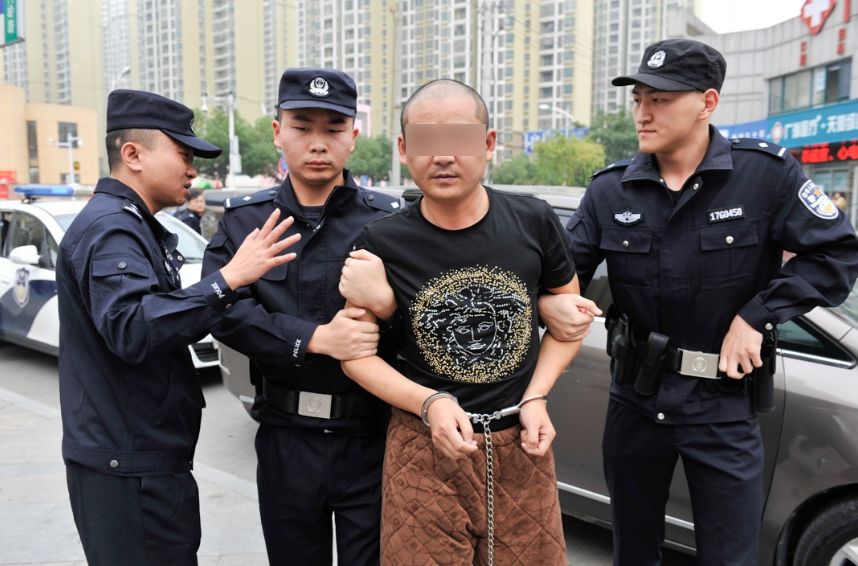 (10月25日上午,主要犯罪嫌疑人张某新被警方押解到作案现场指认)同时