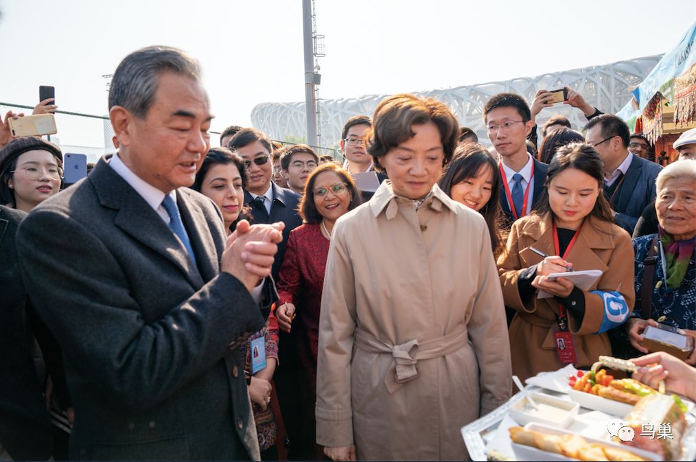 国务委员兼外交部长王毅和夫人钱韦在第十一届国际义卖活动现场参观百