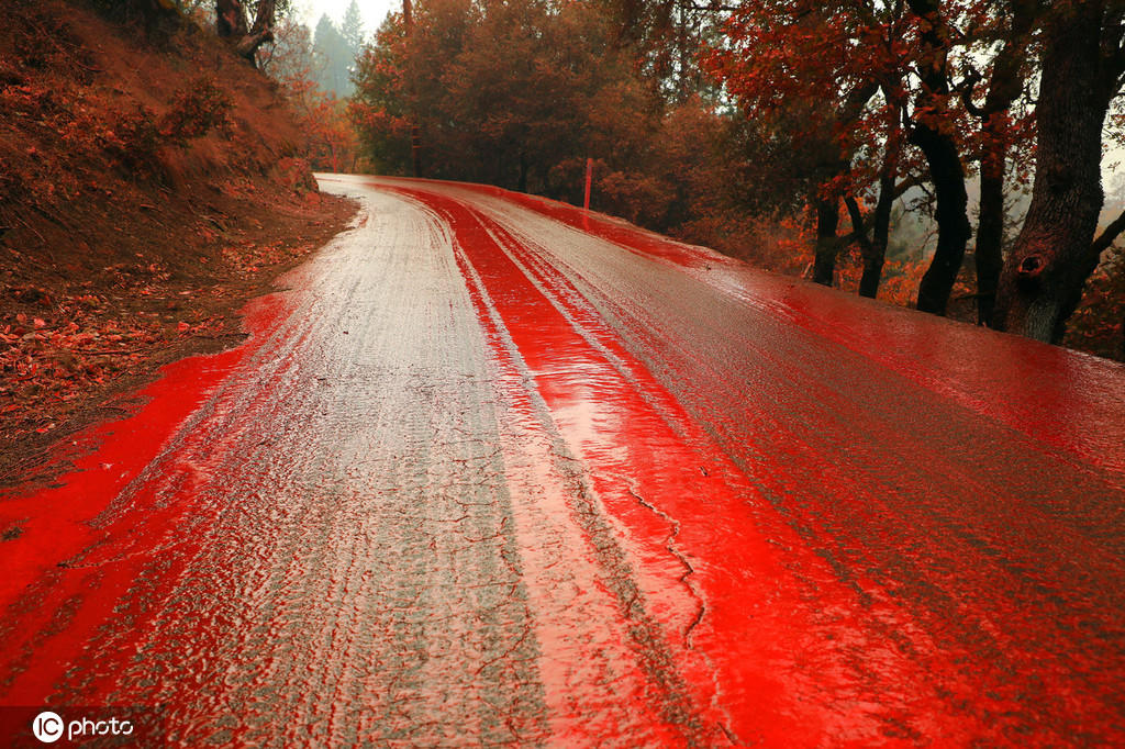 美国加州山火肆虐 灾区车辆道路被喷红色阻燃剂触目惊心