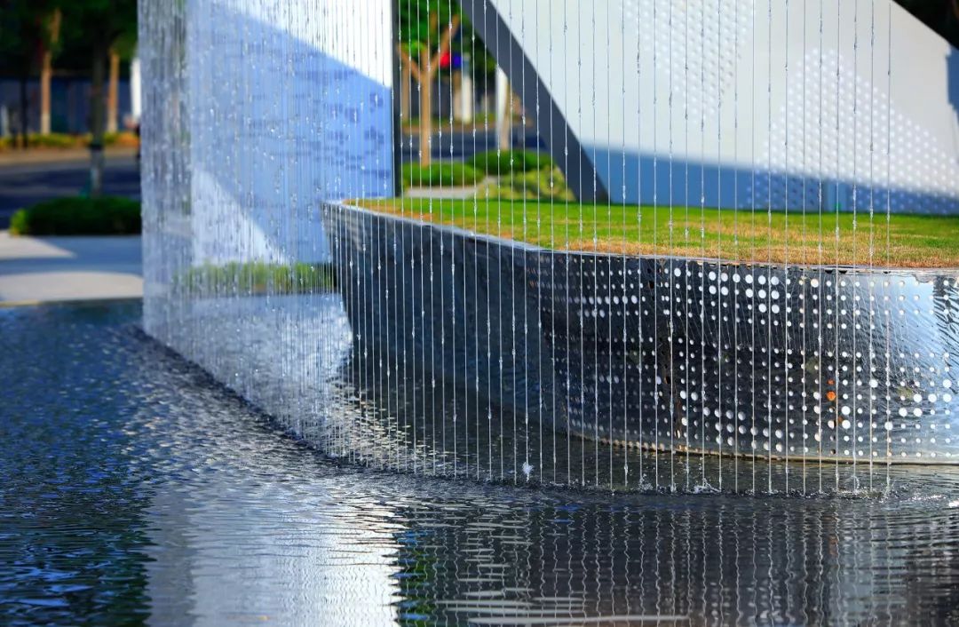 口水帘从景墙潺潺而流,借用景观框景的手法,景墙与水滴雕塑交相辉映