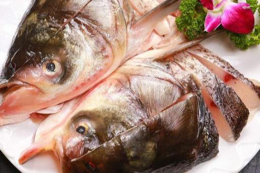 待油热后放入鳙鱼头,文火煎,待鱼头一面稍有淡黄色后,鱼头翻身,再加入