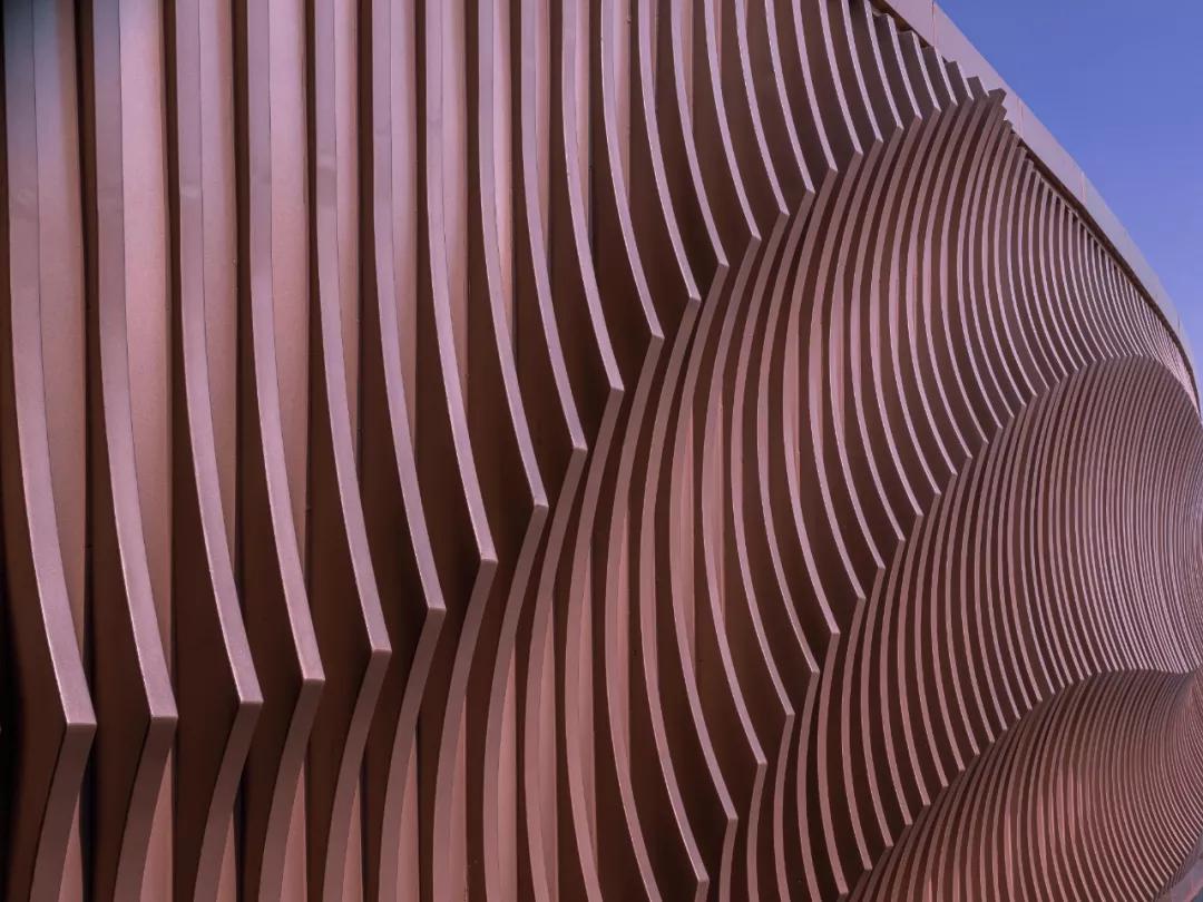 铝板构成入口弧面墙体鱼儿游动之姿抽象于景墙上同时构建了充满未来感