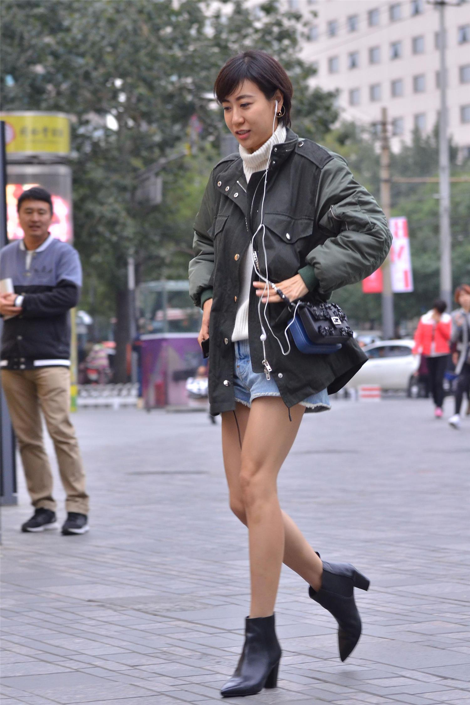 短款的棉服搭配短裤,一双黑色短靴,姑娘这么穿是不是不冷啊?