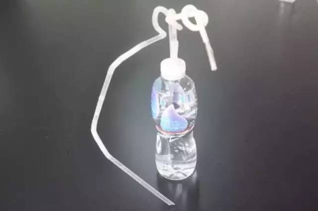 矿泉水瓶的瓶盖上钻了两个洞,一条塑料管一直伸到瓶底,另外一条塑料管