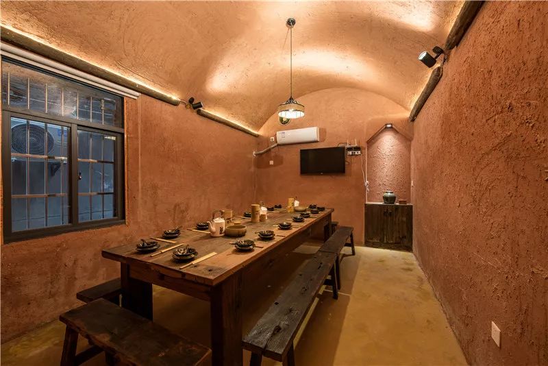 窑洞"这个元素,墙面上继续使用砂浆营造出土墙的质感,圆弧吊顶加上上