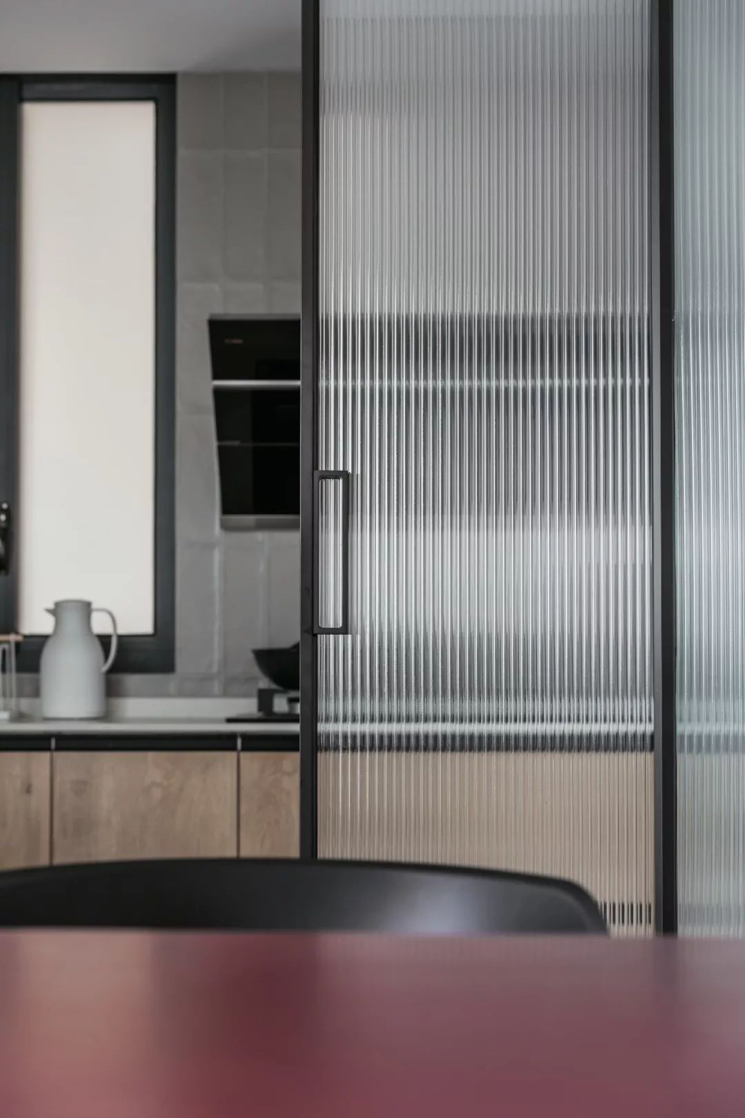 餐厅厨房之间的长虹玻璃门还有侧边的护墙板墙面装饰整体设计显得耐用