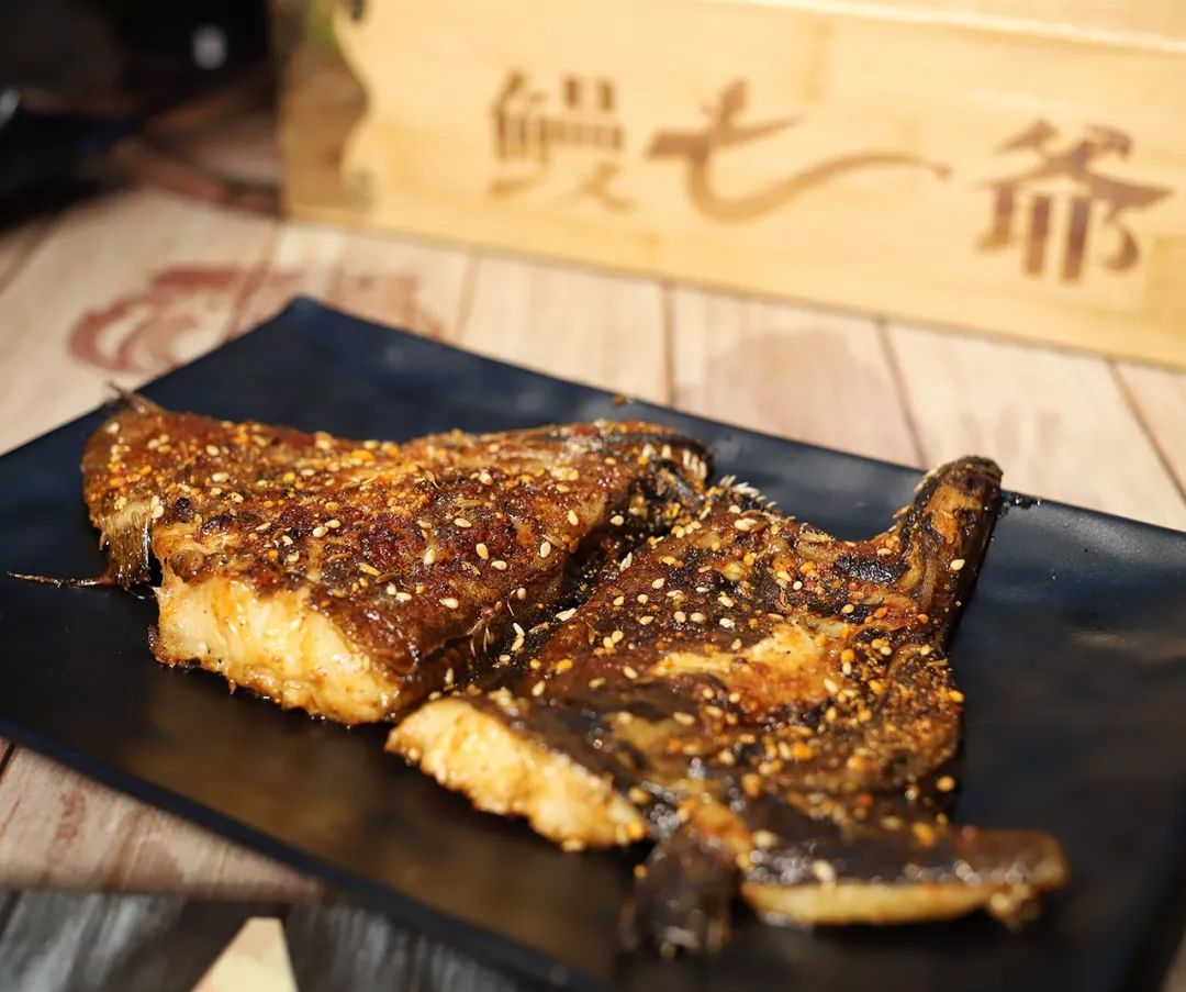 饭桌上常见的清蒸鸦片鱼头在鳗七爷摇身一变,变成了炭烤鱼头.