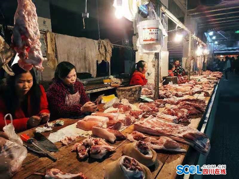 江阳区石马沟农贸市场猪肉铺前空无一人,摊主无所事事.龙欣雨摄