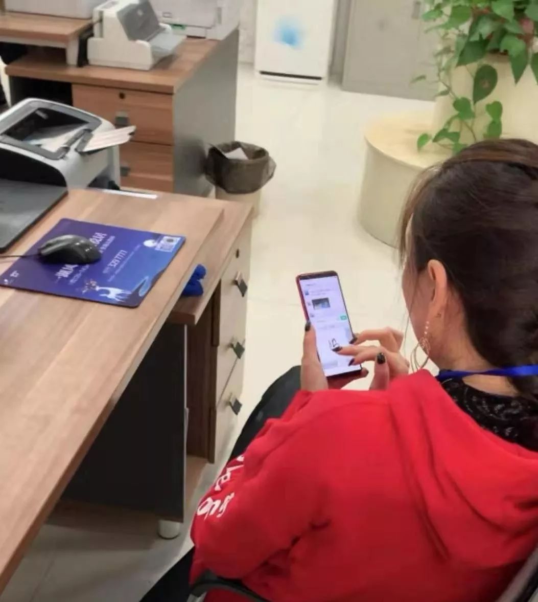 区行政服务大厅综合受理窗口工作人员杜文莉玩手机微信