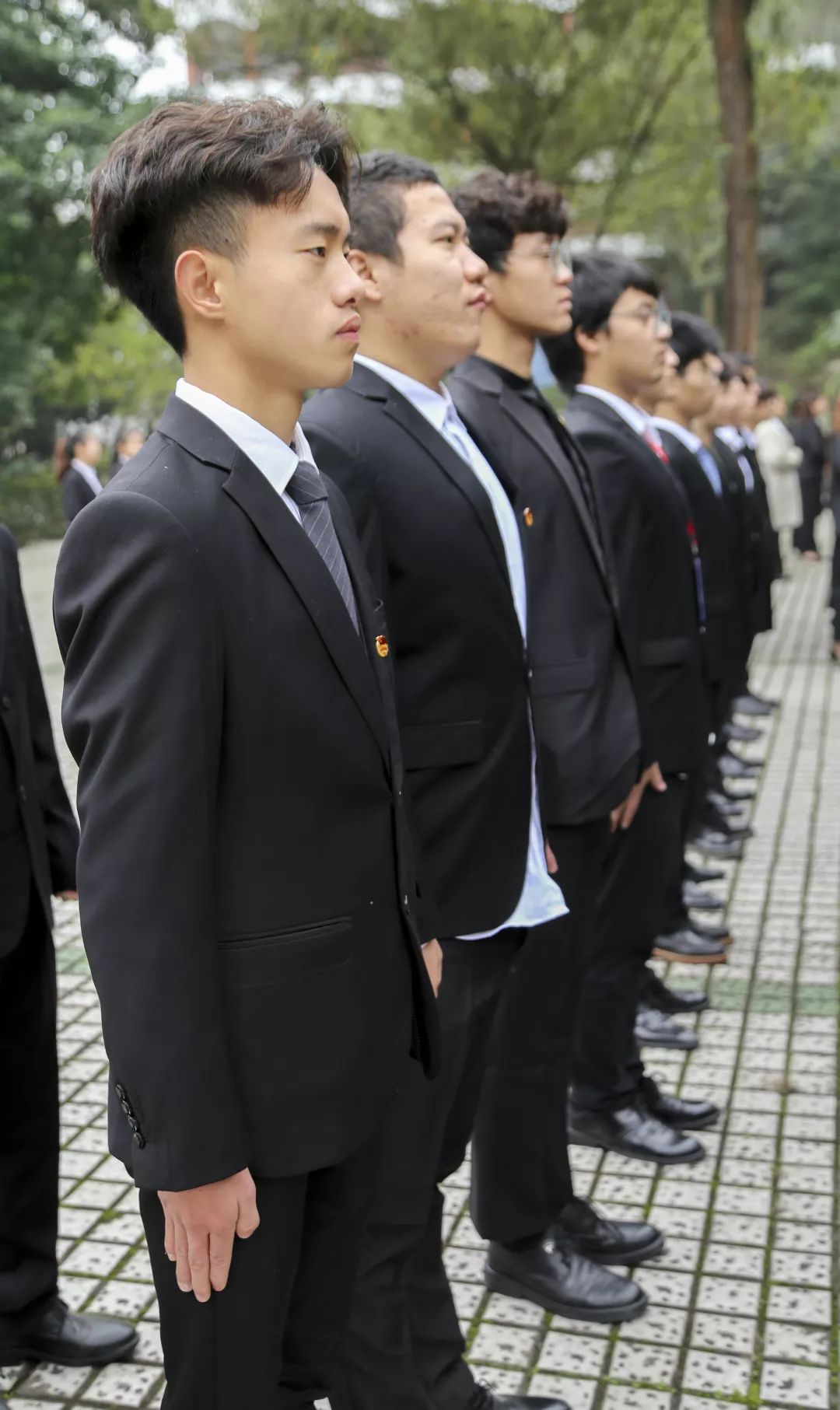 规范的站姿头正:两眼平视前方,嘴微闭,收颌梗颈,表情自然,稍带微笑.