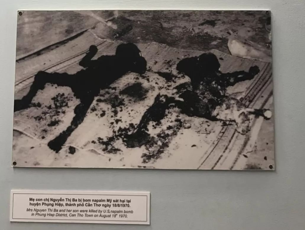 凝固汽油弹活活烧死的母子△一名士兵,手持着半截北越士兵的尸体,这