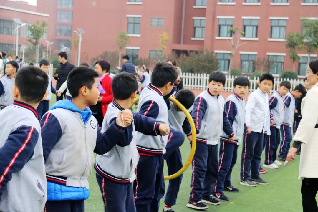>比赛规则:参赛队员手拉手成一列横队站在线上,最左侧学生手拿呼啦圈