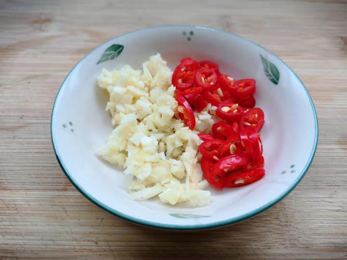 6,炒锅倒油烧热,放入蒜粒红椒圈炒香,再倒入腊肉片翻炒片刻.