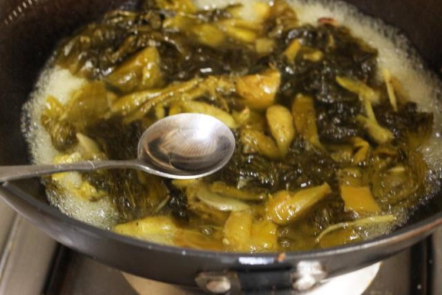 8,锅中放入金针菇烫几十秒,捞出放在汤碗中的酸菜上.